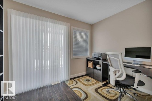 This room features dark hardwood flooring, a window, and a sliding glass doors leading to the deck. - 9540 142 Street, Edmonton, AB - Indoor Photo Showing Office