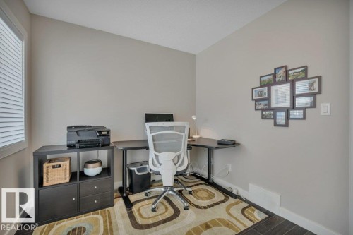 Versatile room featuring a window with blinds, light-colored walls, and dark flooring - 9540 142 Street, Edmonton, AB - Indoor Photo Showing Other Room