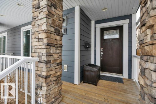The property features a welcoming entrance with a dark wood door, decorative glass inserts, and a covered porch - 9540 142 Street, Edmonton, AB - Outdoor With Deck Patio Veranda With Exterior