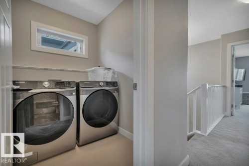 2nd Floor Dedicated laundry area featuring modern front-loading washer and dryer units, a window providing natural light, and neutral-toned walls - 9540 142 Street, Edmonton, AB - Indoor Photo Showing Laundry Room