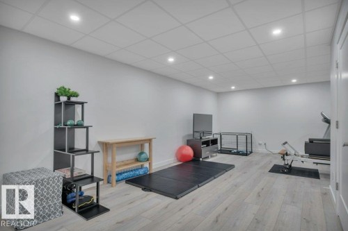 This versatile space features light-toned flooring, recessed lighting, and a white drop ceiling - 9540 142 Street, Edmonton, AB - Indoor