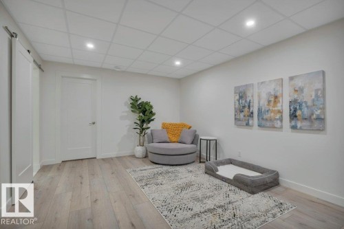 This versatile room features light-colored flooring, recessed lighting, and a white barn door - 9540 142 Street, Edmonton, AB - Indoor Photo Showing Other Room
