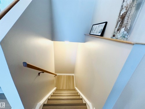 Stairwell featuring a wood handrail, light-colored walls, and recessed lighting - 15 Pinecliff Close Ne, Calgary, AB - Indoor Photo Showing Other Room