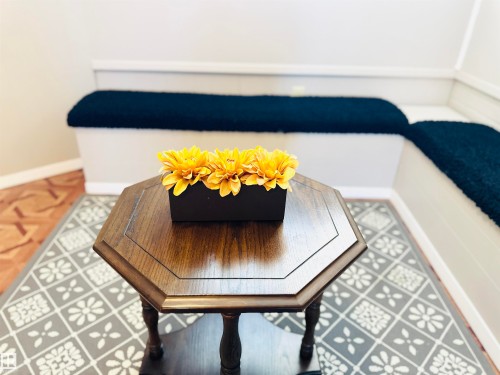 This inviting space features built-in white benches with dark blue cushions, complemented by patterned floor coverings - 15 Pinecliff Close Ne, Calgary, AB - Indoor Photo Showing Other Room