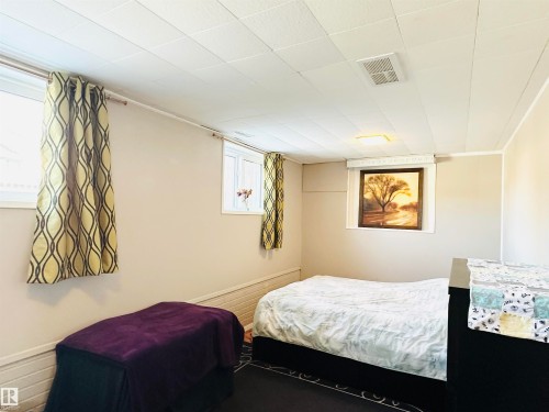This room features light-toned walls, a white ceiling, and windows with patterned curtains - 15 Pinecliff Close Ne, Calgary, AB - Indoor Photo Showing Bedroom