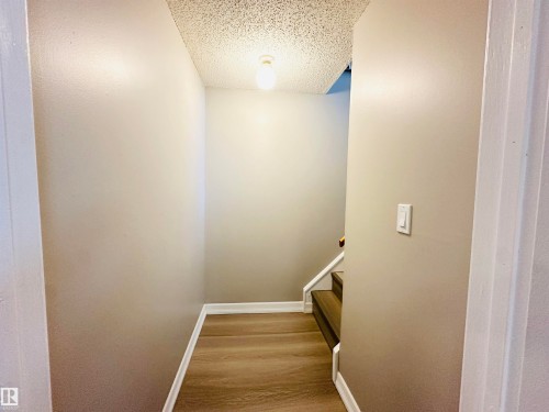 The property features light-colored walls, a textured ceiling, and wood-look flooring - 15 Pinecliff Close Ne, Calgary, AB - Indoor Photo Showing Other Room