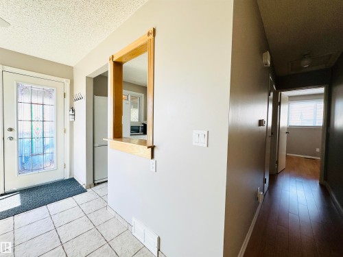 The entry features tiled flooring and a door with decorative glass inserts - 15 Pinecliff Close Ne, Calgary, AB - Indoor Photo Showing Other Room