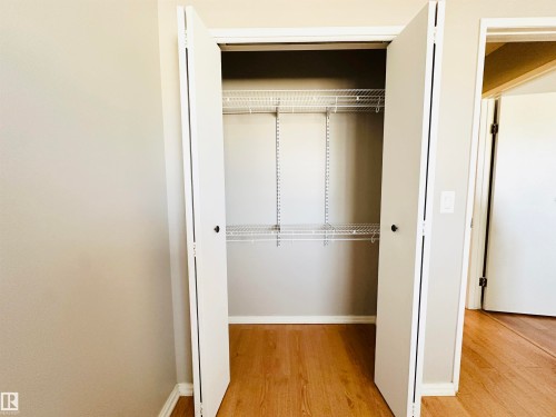 Closet with bi-fold doors, wire shelving, and wood flooring - 15 Pinecliff Close Ne, Calgary, AB - Indoor