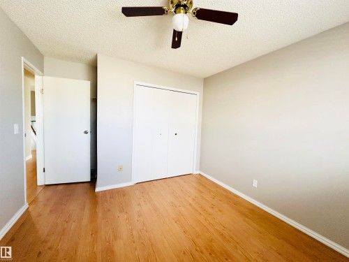 This inviting interior space features light-colored walls, wood-style flooring, and a ceiling fan - 15 Pinecliff Close Ne, Calgary, AB - Indoor Photo Showing Other Room