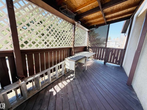 The property features a private outdoor area with wooden decking and a lattice design privacy screen - 15 Pinecliff Close Ne, Calgary, AB - Outdoor With Deck Patio Veranda With Exterior