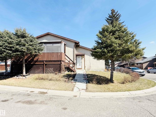 The property features a front yard with a lawn and mature evergreen trees - 15 Pinecliff Close Ne, Calgary, AB - Outdoor