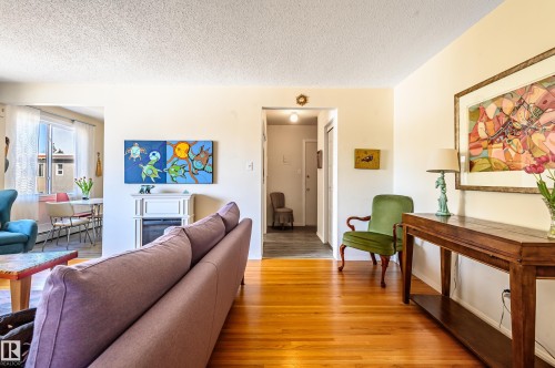 The living room features hardwood flooring and an entryway leading to a separate area - 12 6805 112 Street, Edmonton, AB - Indoor Photo Showing Living Room