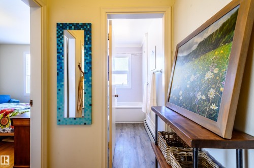 The property features a hallway with light-colored walls and wood-look flooring - 12 6805 112 Street, Edmonton, AB - Indoor