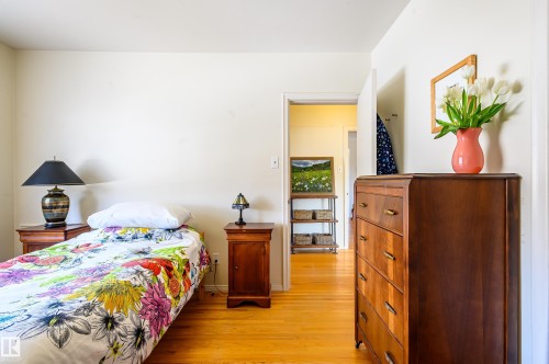 The property features light-toned walls and hardwood floors, creating a bright and inviting atmosphere - 12 6805 112 Street, Edmonton, AB - Indoor Photo Showing Bedroom