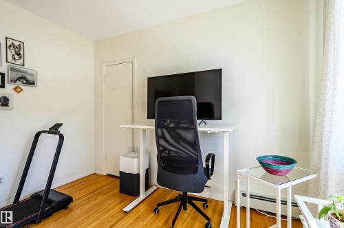 This room features hardwood floors and a window with sheer curtains - 12 6805 112 Street, Edmonton, AB - Indoor Photo Showing Office
