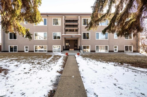 The property features a three-story exterior with a stucco finish and numerous windows, providing ample natural light - 12 6805 112 Street, Edmonton, AB - Outdoor