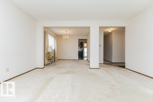 Spacious interior featuring light-toned carpeting and white walls - 8804 19 Avenue, Edmonton, AB - Indoor Photo Showing Other Room