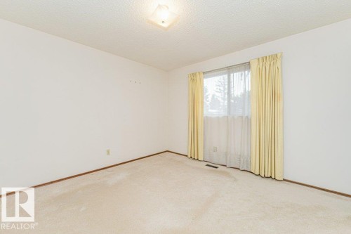 This room features a window with curtains, carpeted flooring, and a ceiling light fixture - 8804 19 Avenue, Edmonton, AB - Indoor Photo Showing Other Room