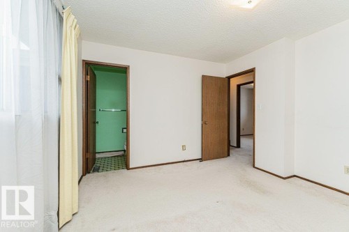 The property features a room with light-colored carpeting, white walls, and a textured ceiling - 8804 19 Avenue, Edmonton, AB - Indoor Photo Showing Other Room