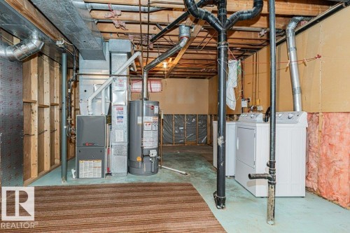 The utility area features a water heater, furnace, laundry appliances, and exposed overhead pipes - 8804 19 Avenue, Edmonton, AB - Indoor Photo Showing Basement