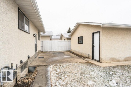 The property features an exterior with stucco siding, a concrete pathway, and a detached garage with a side entry door and a window - 8804 19 Avenue, Edmonton, AB - Outdoor With Exterior