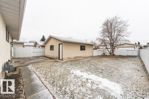 The property features a detached building with a door and window, a paved pathway, and a bare tree - 8804 19 Avenue, Edmonton, AB - Outdoor