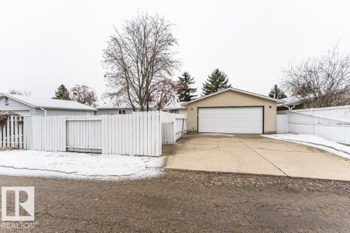 Detached garage with a driveway and a white fence - 8804 19 Avenue, Edmonton, AB - Outdoor
