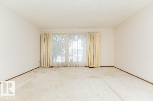 This room features light-colored carpeting and white walls, creating a bright and airy atmosphere - 8804 19 Avenue, Edmonton, AB - Indoor Photo Showing Other Room