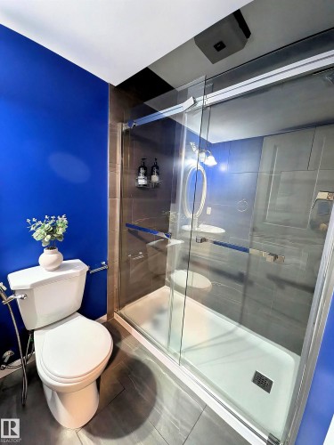 The bathroom features a modern glass-enclosed shower with a white base and a toilet with an attached bidet - 225 51A Street, Edmonton, AB - Indoor Photo Showing Bathroom