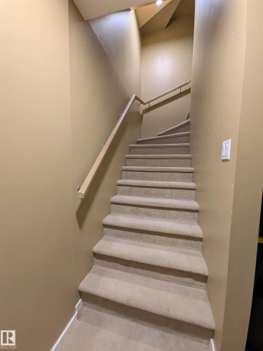 Carpeted staircase featuring a light-toned handrail and recessed lighting - 225 51A Street, Edmonton, AB - Indoor Photo Showing Other Room