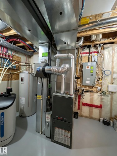 Utility room with finished concrete flooring, a water heater, and an HVAC system - 225 51A Street, Edmonton, AB - Indoor Photo Showing Basement