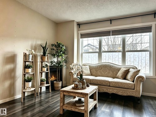 Living area featuring dark wood flooring, a fireplace, and a large window with privacy film - 225 51A Street, Edmonton, AB - Indoor Photo Showing Living Room