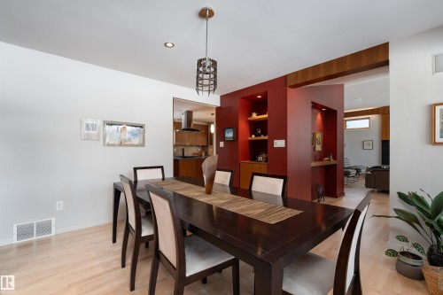Dining area featuring hardwood floors, a modern light fixture, and a built-in display niche with shelving - 9715 141 Street Nw, Edmonton, AB - Indoor Photo Showing Dining Room