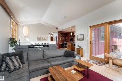 The property features an open-concept living area with light hardwood floors and a vaulted ceiling - 