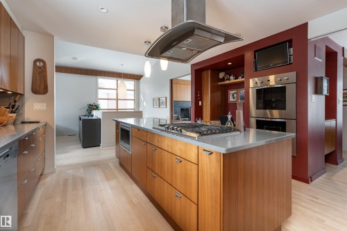 The kitchen features an island with a cooktop, a built-in microwave, and pendant lighting - 9715 141 Street Nw, Edmonton, AB - Indoor Photo Showing Kitchen