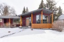 The property features a contemporary architectural style with a prominent sloped roofline, large windows, and natural wood accents - 9715 141 Street Nw, Edmonton, AB  - Outdoor With Deck Patio Veranda 