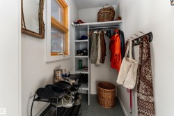 This area features a window with natural wood trim, a built-in storage system with shelving and hanging space, and a wall-mounted rack with hooks - 