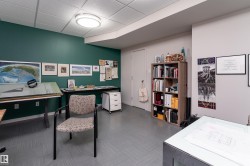 This room features a distinct dark green accent wall, light-colored walls, and a ceiling with recessed lighting - 