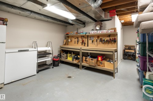 The property features a utility room with a workbench and storage shelving - 9715 141 Street Nw, Edmonton, AB - Indoor Photo Showing Basement