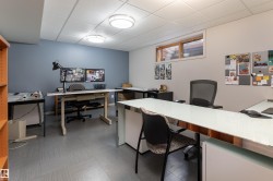 The property features a versatile room with a drop ceiling, recessed lighting, and grey flooring - 