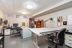 Versatile room featuring a drop ceiling with flush-mount lighting, light-colored walls, and a patterned floor - 