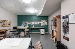 Versatile room with a dark teal accent wall, recessed lighting, and light-colored ceiling tiles - 