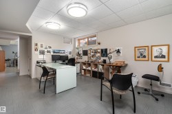 The property features a versatile room with light grey walls, grey floor tiles, and recessed lighting fixtures - 