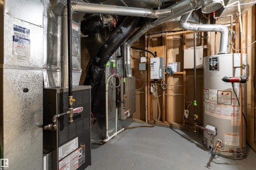 Utility area featuring a water heater, furnace, and exposed ductwork - 9715 141 Street Nw, Edmonton, AB - Indoor Photo Showing Basement