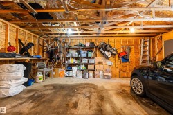 The property offers a garage space featuring exposed wooden ceiling beams and wooden wall construction - 