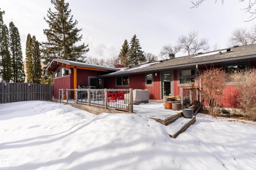 The property features a red exterior, a wood deck with railings, and a fenced yard - 9715 141 Street Nw, Edmonton, AB - Outdoor With Deck Patio Veranda