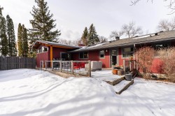 The property features a red exterior, a wood deck with railings, and a fenced yard - 