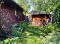 The property features a well-maintained lawn with stepping stones, bordered by various plantings - 