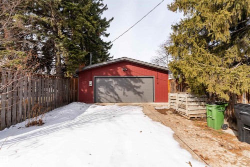 The property features a detached garage with a red exterior and a gray garage door - 9715 141 Street Nw, Edmonton, AB - Outdoor