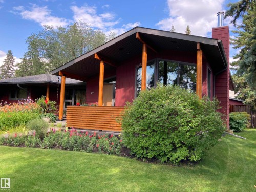 The property features a rich red exterior with a prominent wooden-slatted planter box - 9715 141 Street Nw, Edmonton, AB - Outdoor With Deck Patio Veranda